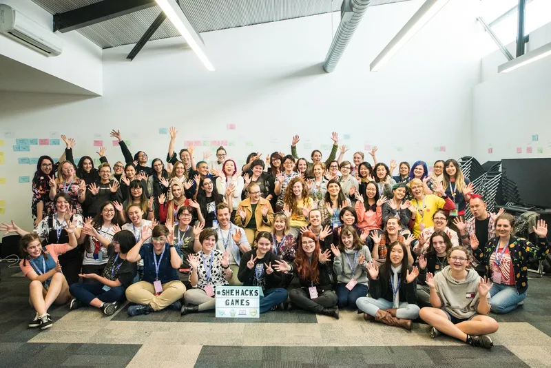 A huge group of #SheHacksGames participants cheering at The Arcade Melbourne