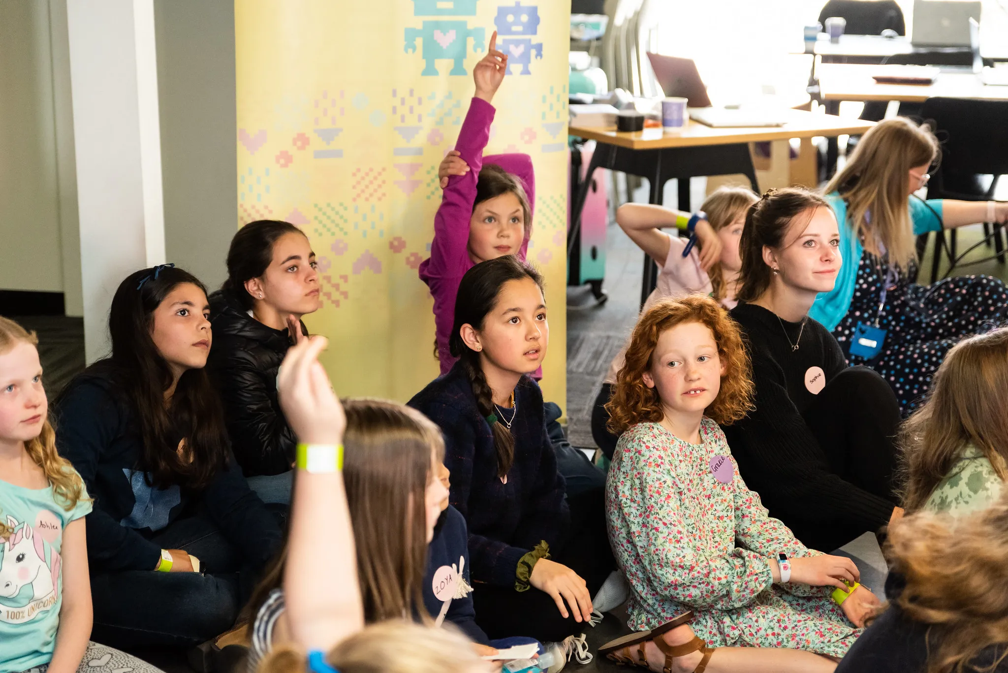 Girls putting their hands up during a workshop