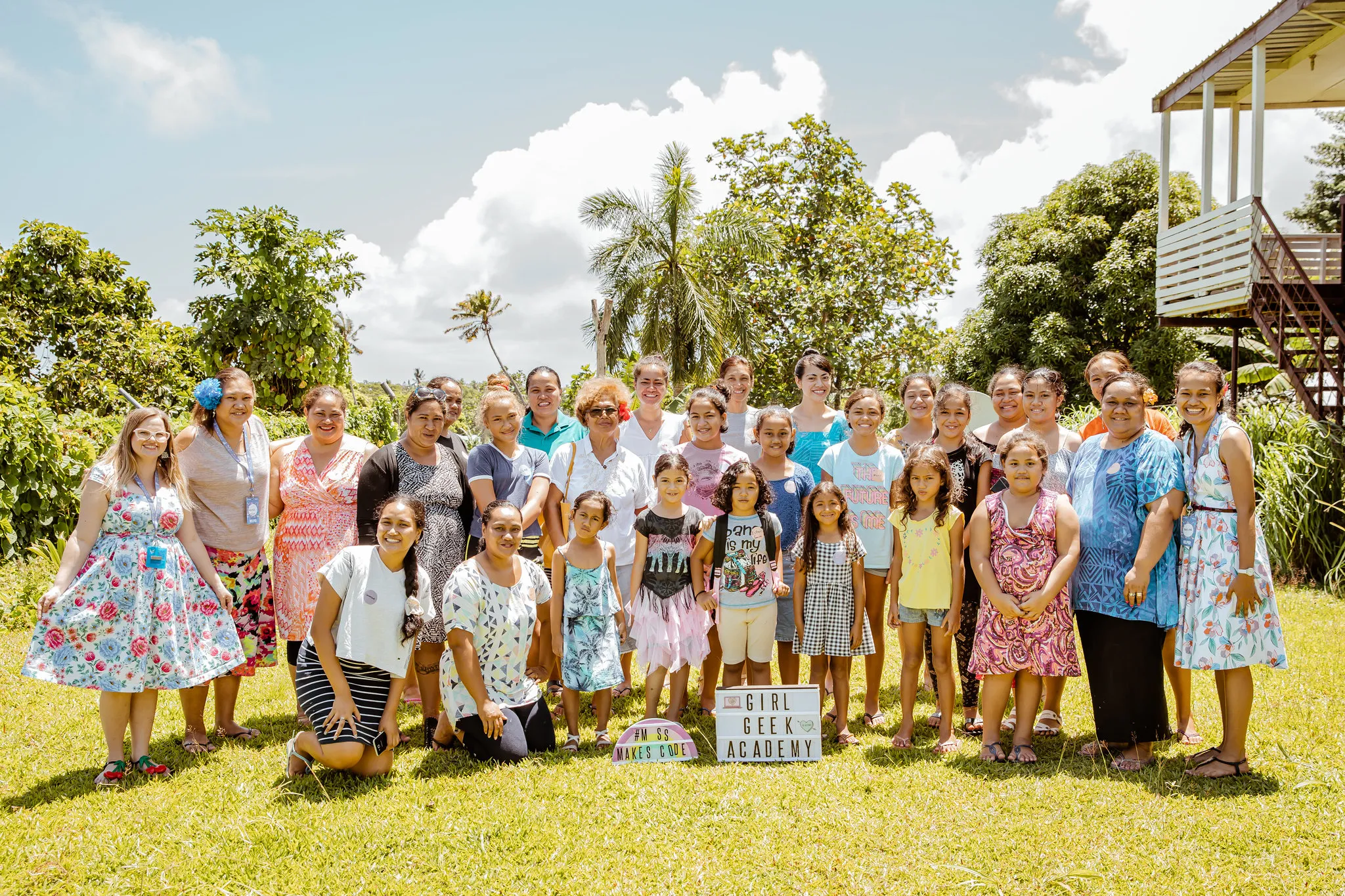 Participants and families in a group photo on the lawn