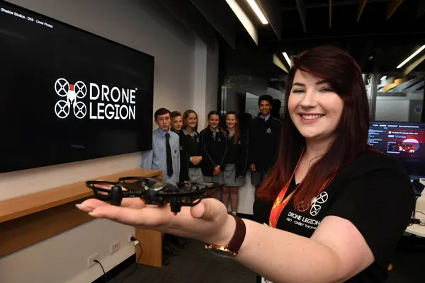 Casey Thomas holding a small racing drone at a Drone Legion event