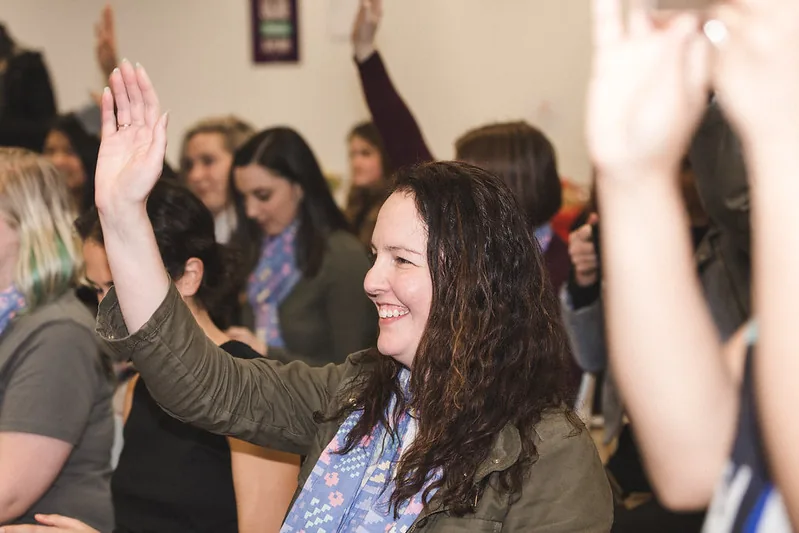 A smiling participant with her hand up at #SheHacks 2016
