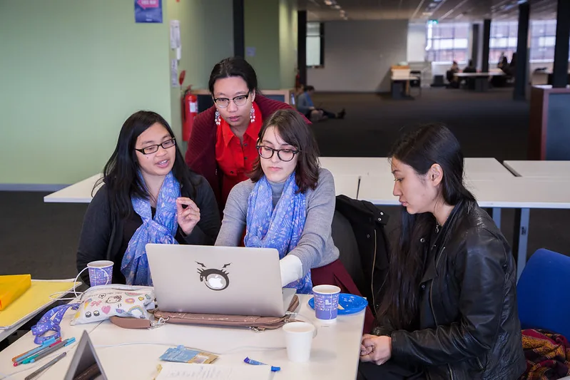 A team of four gathered around one laptop at #SheHacks 2017