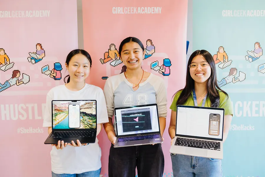 Three students holding up laptops showing their apps