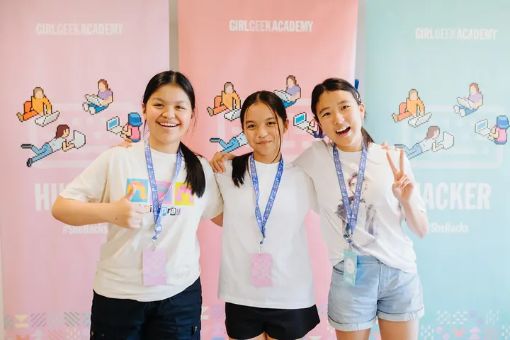 Three students smiling at the camera